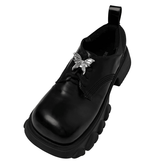 A silver metallic 3D butterfly shoelace charm with raised wings, creating a sculptural and dynamic look on sneakers.