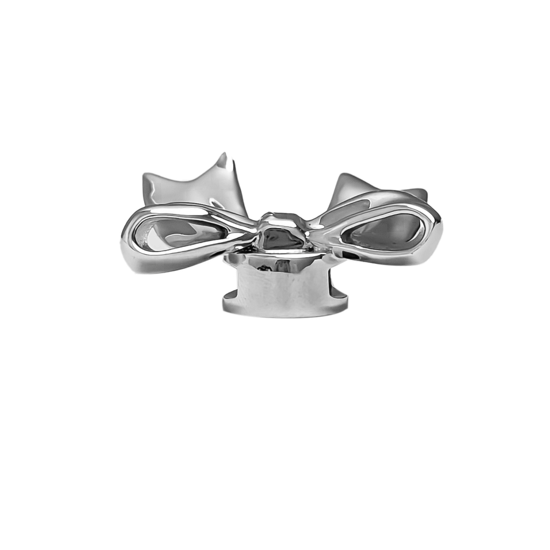 A silver metallic bow knot shoelace charm with a polished finish, adding a stylish and elegant accent to sneakers.