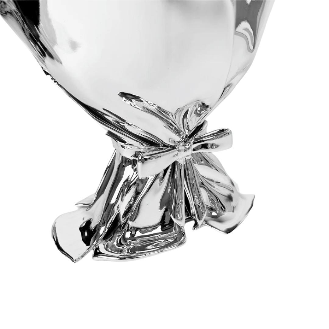 Futuristic chrome bouquet vase with sculptural ribbon tie – reflective metallic “petal” sheets gathered at the base, forming an abstract floral vessel