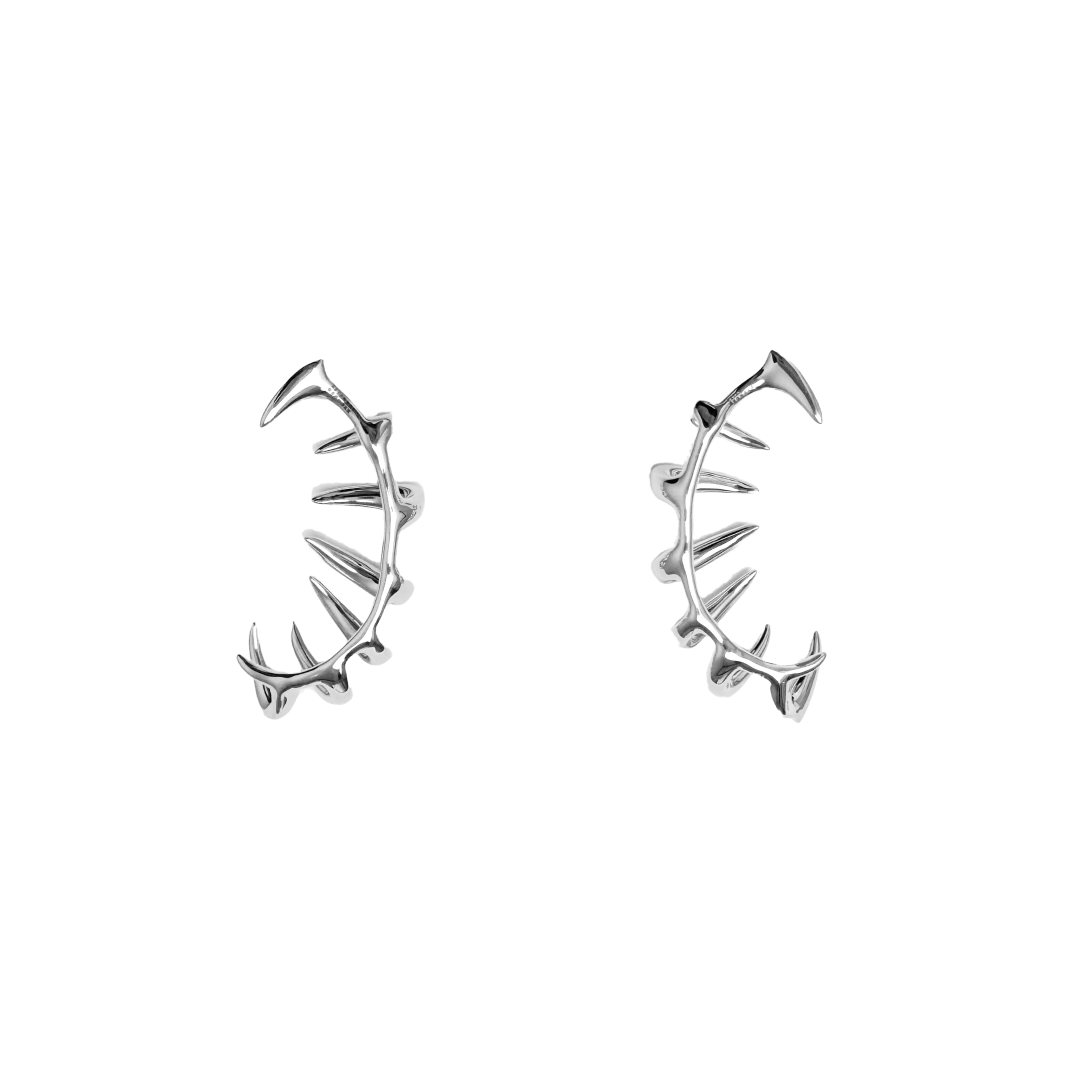 Claw Ear Cuffs — claw-shaped ear cuffs encircling the ear with sleek, sculptural curves, available in black and silver.