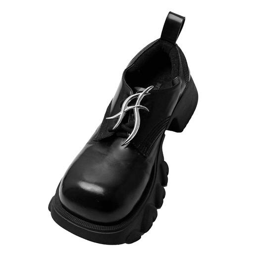 The XTENDED iDENTiTY "Cyber Dreams" Shoelry from the Cyber Dream series. A single-piece ornament featuring a fluid, abstract metallic design resembling a sharp, futuristic letter or symbol. Available finishes include Shadow Black, Liquid Silver, and Molten Gold, displayed together.