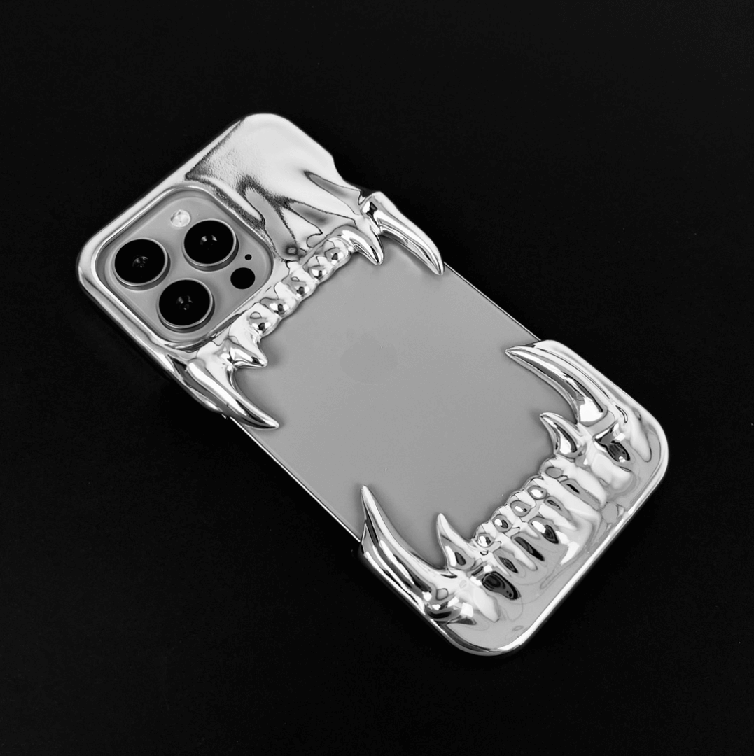 Metallic silver iPhone case with fierce dragon fang design – upper and lower jaws grip the phone edges, creating a bold, high-impact gothic aesthetic.