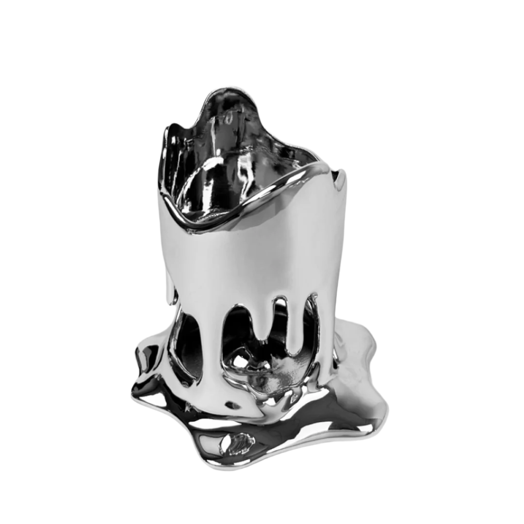 Futuristic chrome drip candleholder with real taper candle – sculptural molten-“wax” metal drips pooling at the base, cradling a lit pillar for fluid minimalist elegance