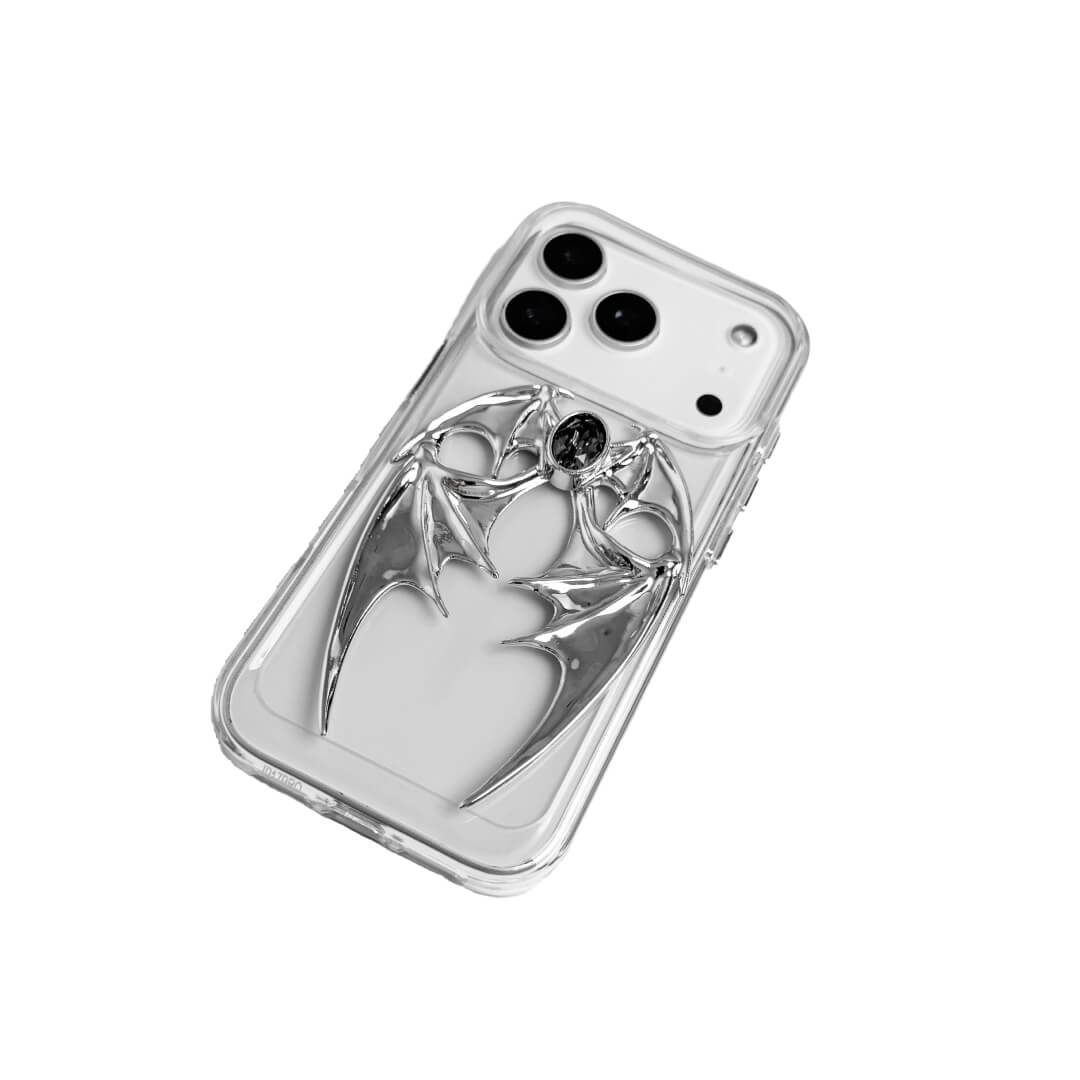 The Gem Demon Wings iPhone Case featuring 3D sculpted silver metallic bat-style wings with a central rhinestone. Shown with both White and Black gem options, available on Silver, Transparent, and Black case bases.