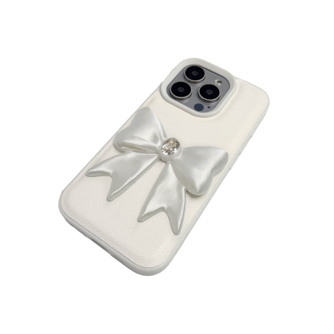 The Glossy White Gem Bow iPhone Case featuring the stunning 3D sculpted white bow with a central gem embellishment, shown on both the Crystal Clear (Transparent) and White Leather Texture base options.