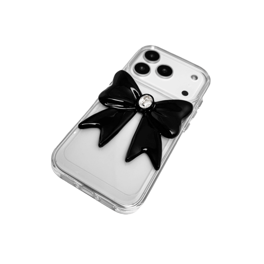 Midnight Gem Bow iPhone Case with 3D bow design, available in mirror silver and glossy black. Swarovski crystal centerpiece offered in black, white, or pink.