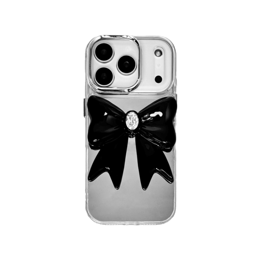 Midnight Gem Bow iPhone Case with 3D bow design, available in mirror silver and glossy black. Swarovski crystal centerpiece offered in black, white, or pink.