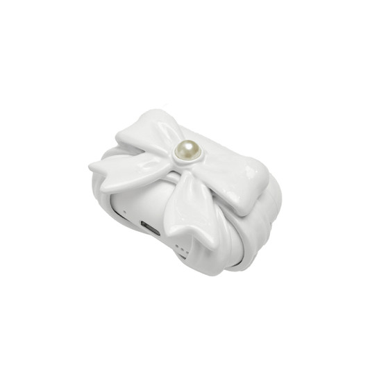 A pair of protective covers for Apple AirPods (or AirPods Pro) charging case. Each cover is white and features a large, 3D sculpted bow charm centered on the front. One bow is glossy black and the other is pure white, with a single white pearl embedded in the center of each.