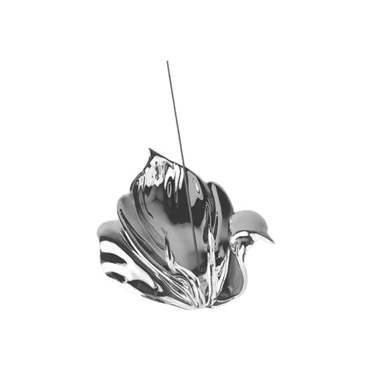 Futuristic chrome incense holder with flowing petal silhouette – organic metallic design cradling incense stick in sculptural bloom