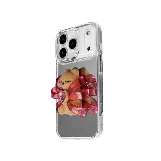 Ribbon Magic Bear iPhone Case – Pink Edition featuring a beige gummy bear holding a pink crystal heart, framed by shimmering metallic pink ribbons.