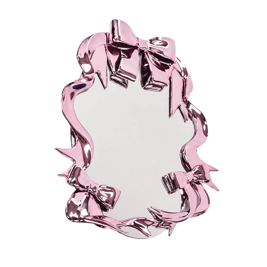 Futuristic 3D ribbon mirror in glossy pink chrome – sculptural bow-and-streamer frame surrounding an oval reflective surface with playful baroque flair