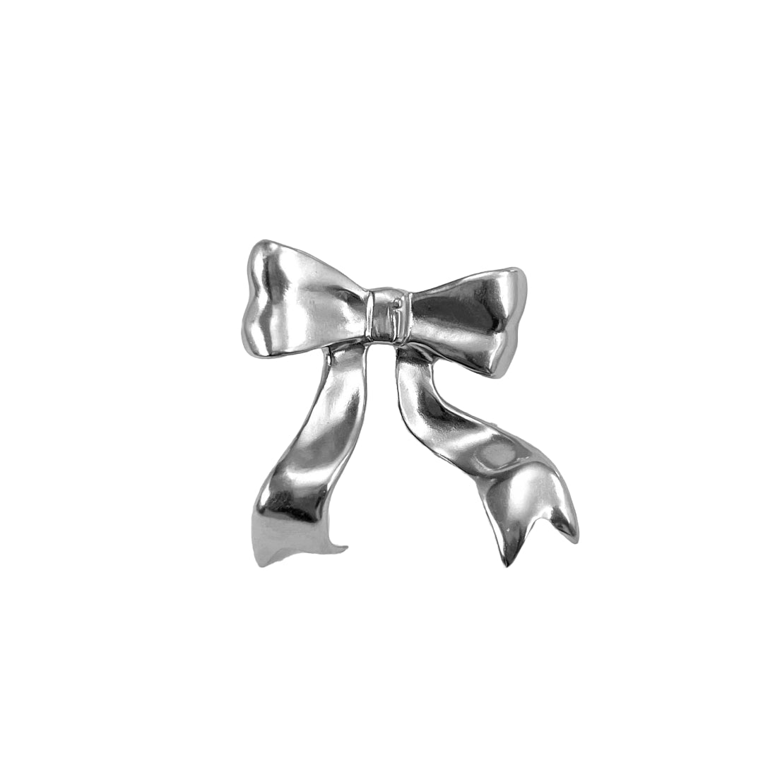 Polished silver bow-shaped accessory attached to the side of black AirPods Max headphones.