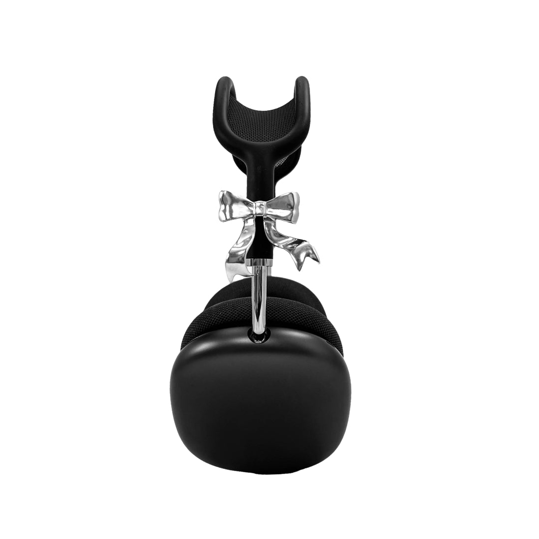 Polished silver bow-shaped accessory attached to the side of black AirPods Max headphones.