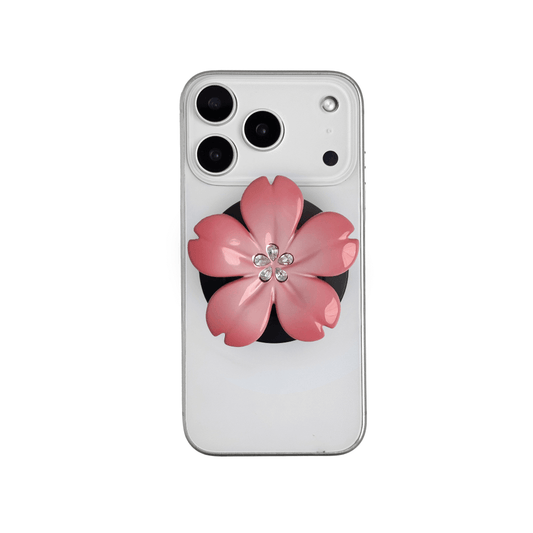 Magnetic phone grip with a silver mirror finish, decorated with a cherry blossom in pink or silver tones accented by five sparkling crystals for a luxurious, floral-inspired look.