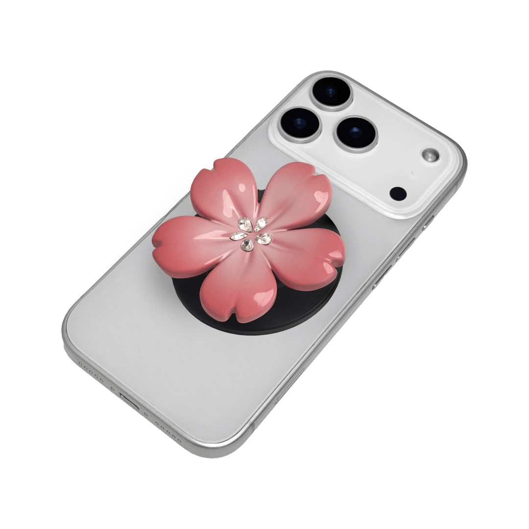 Magnetic phone grip with a silver mirror finish, decorated with a cherry blossom in pink or silver tones accented by five sparkling crystals for a luxurious, floral-inspired look.
