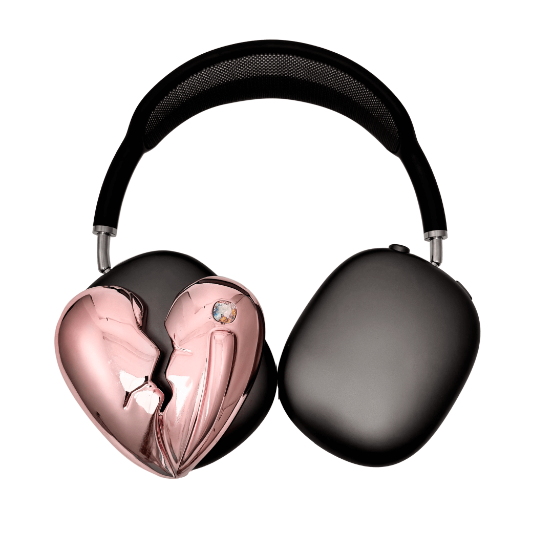 Silver, pink, red and black AirPods Max cover featuring a metallic broken heart design, with a sculpted crack down the center and small embedded crystal detail.