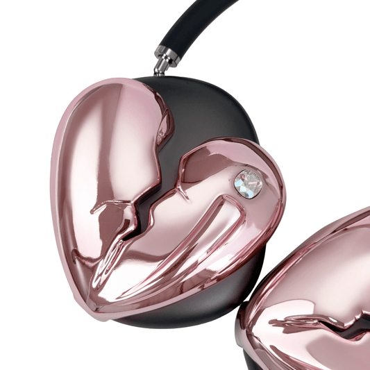 Silver, pink, red and black AirPods Max cover featuring a metallic broken heart design, with a sculpted crack down the center and small embedded crystal detail.