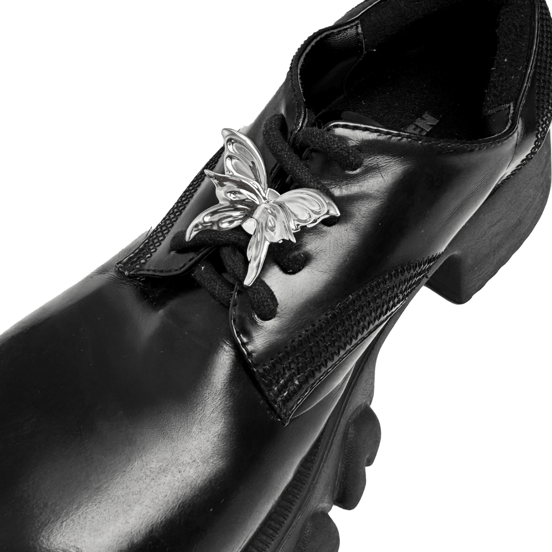 A silver metallic 3D butterfly shoelace charm with raised wings, creating a sculptural and dynamic look on sneakers.