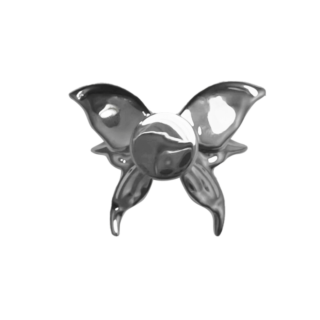 A silver metallic 3D butterfly shoelace charm with raised wings, creating a sculptural and dynamic look on sneakers.