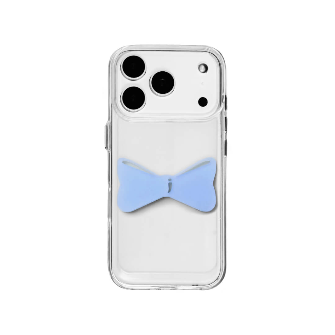 A modern iPhone case featuring a 3D acrylic bow/ribbon ornament. Available in Sakura Pink and Azure Blue acrylic finishes. The case is shown on both a Reflective Silver metallic base and a Clear Transparent base, showcasing a minimalist yet playful fashion aesthetic.