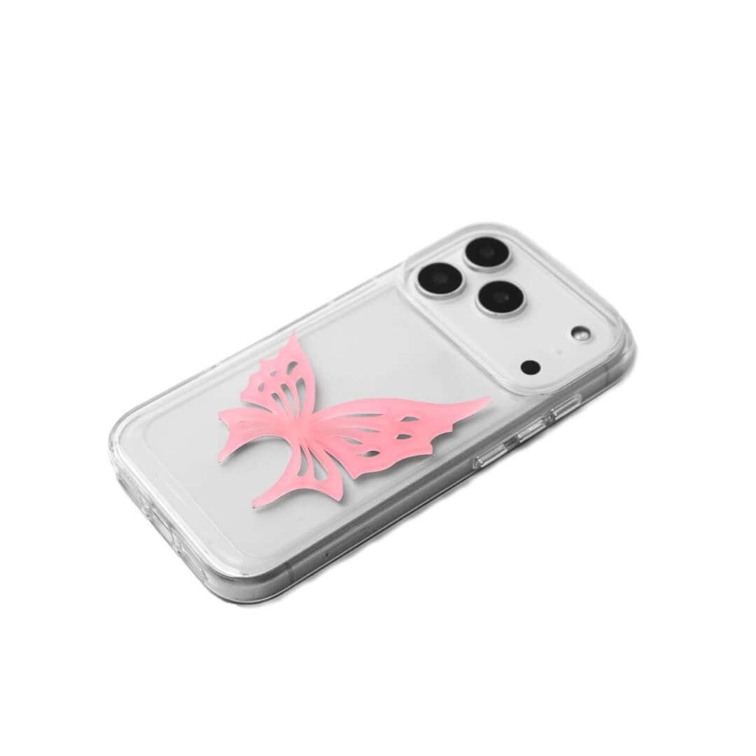 A luxury iPhone case featuring a large 3D acrylic butterfly ornament with delicate wing cutouts. Available in two translucent colors: Sakura Pink and Azure Blue. The butterfly is mounted on a Clear Transparent base, creating a romantic and ethereal floating effect.