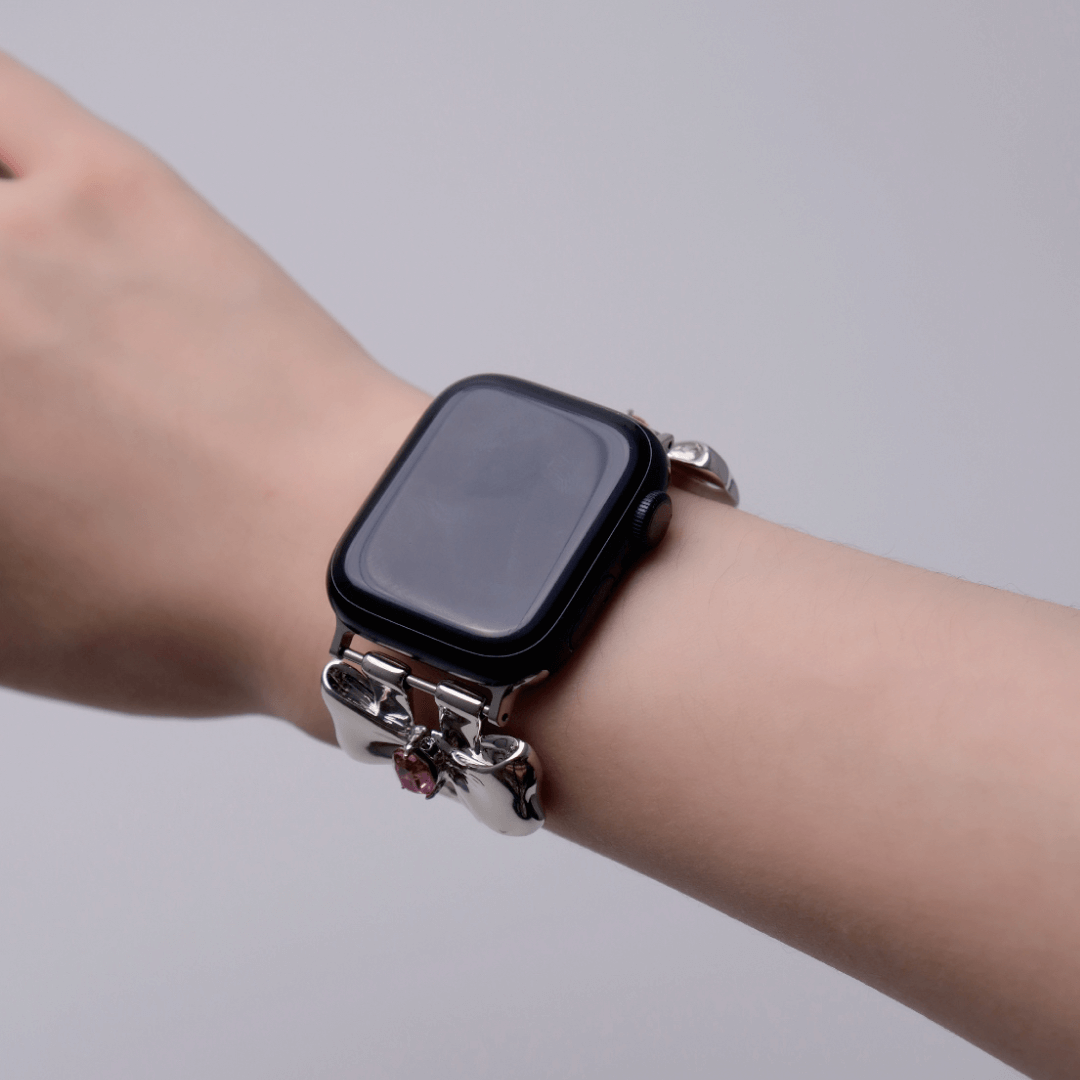 Smartwatch with decorative band on a wrist against a plain background