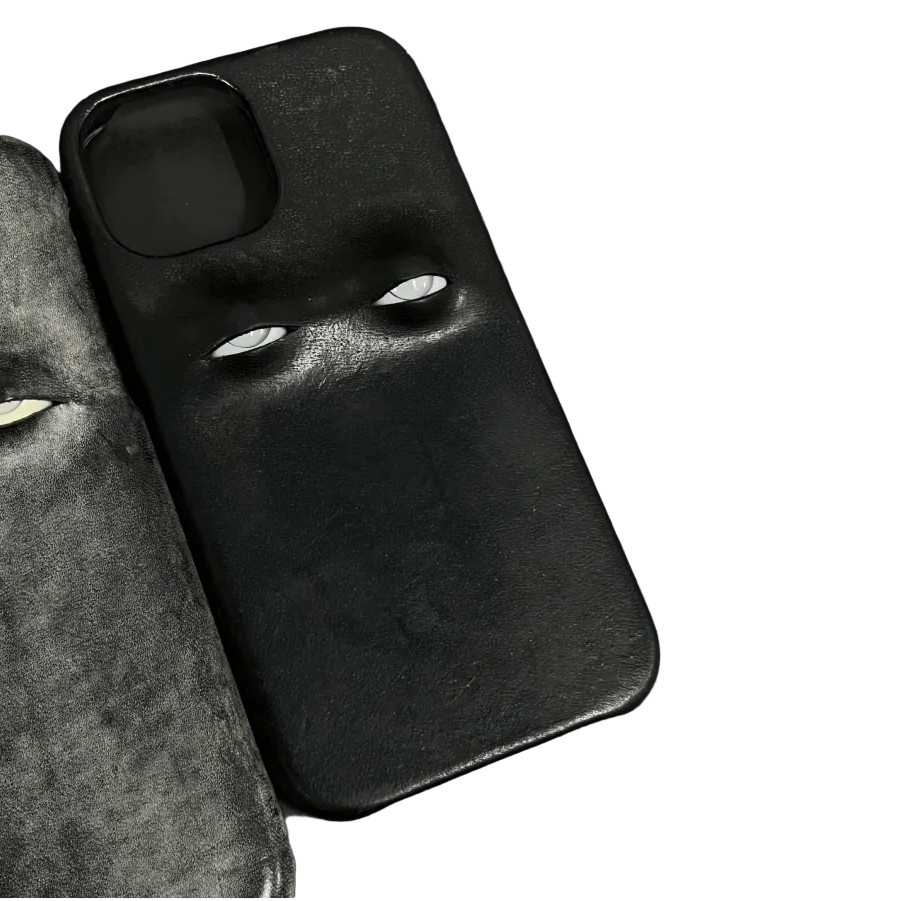 Black phone case with a face design on a black surface