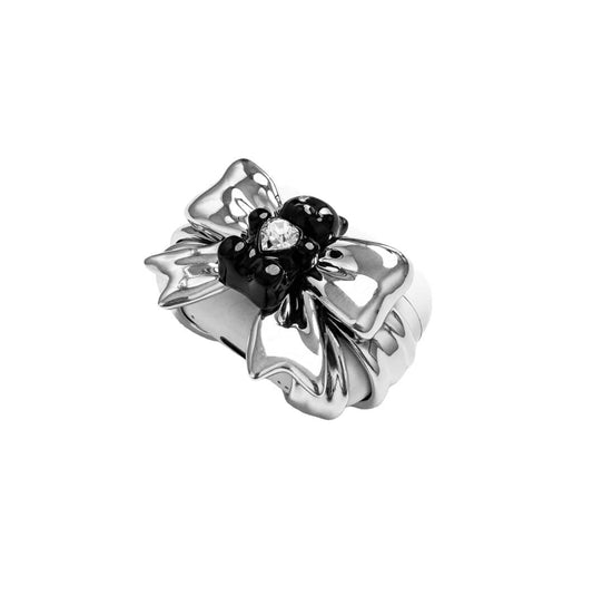Bow Magic Bear AirPods Cover featuring a glossy black gummy bear holding a crystal heart, centered on metallic silver bow-shaped detailing.