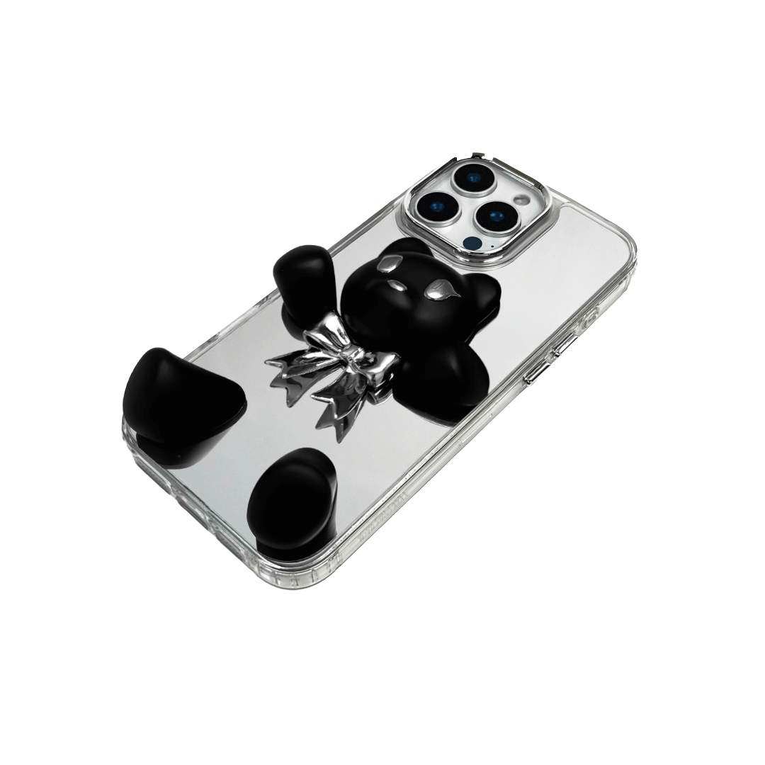 Transparent mirror phone case with a 3D teddy bear in brown flocking, wearing a black bow tie.