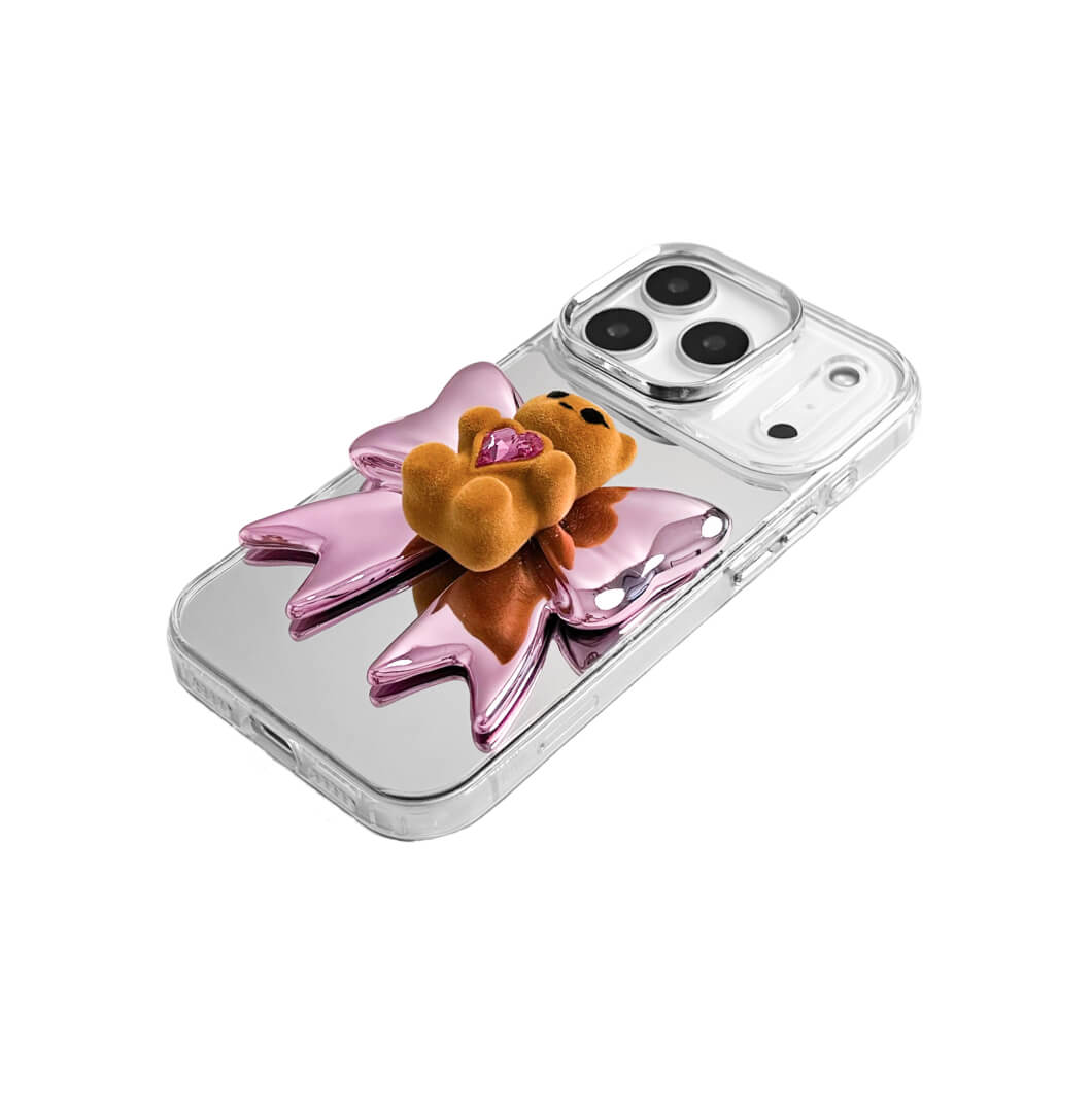 Bow Magic Bear iPhone Case - Pink Edition featuring a beige gummy bear holding a pink crystal heart, set against a metallic pink bow design.