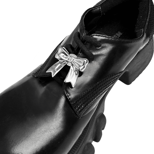 A silver metallic bow knot shoelace charm with a polished finish, adding a stylish and elegant accent to sneakers.