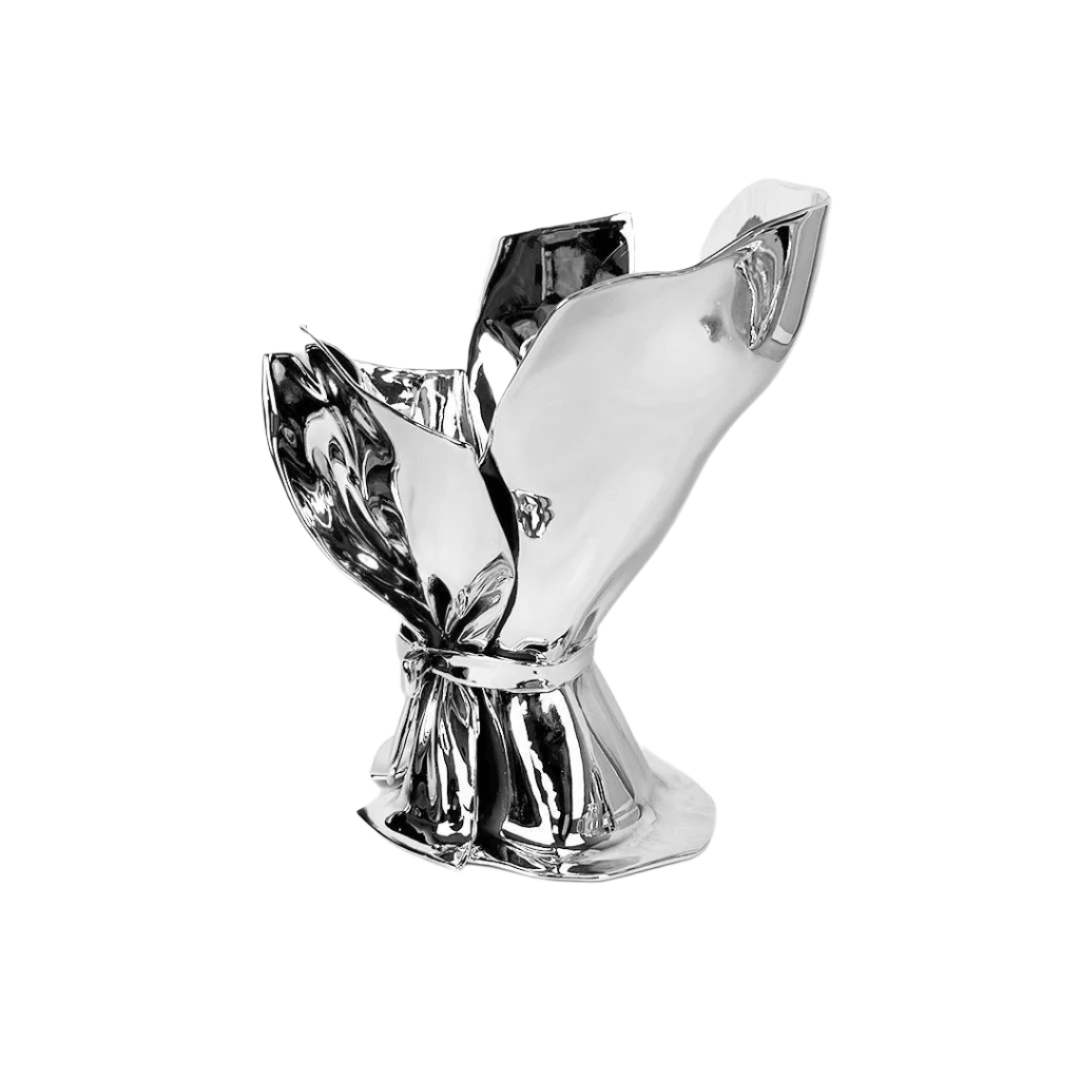 Futuristic chrome bouquet vase with sculptural ribbon tie – reflective metallic “petal” sheets gathered at the base, forming an abstract floral vessel