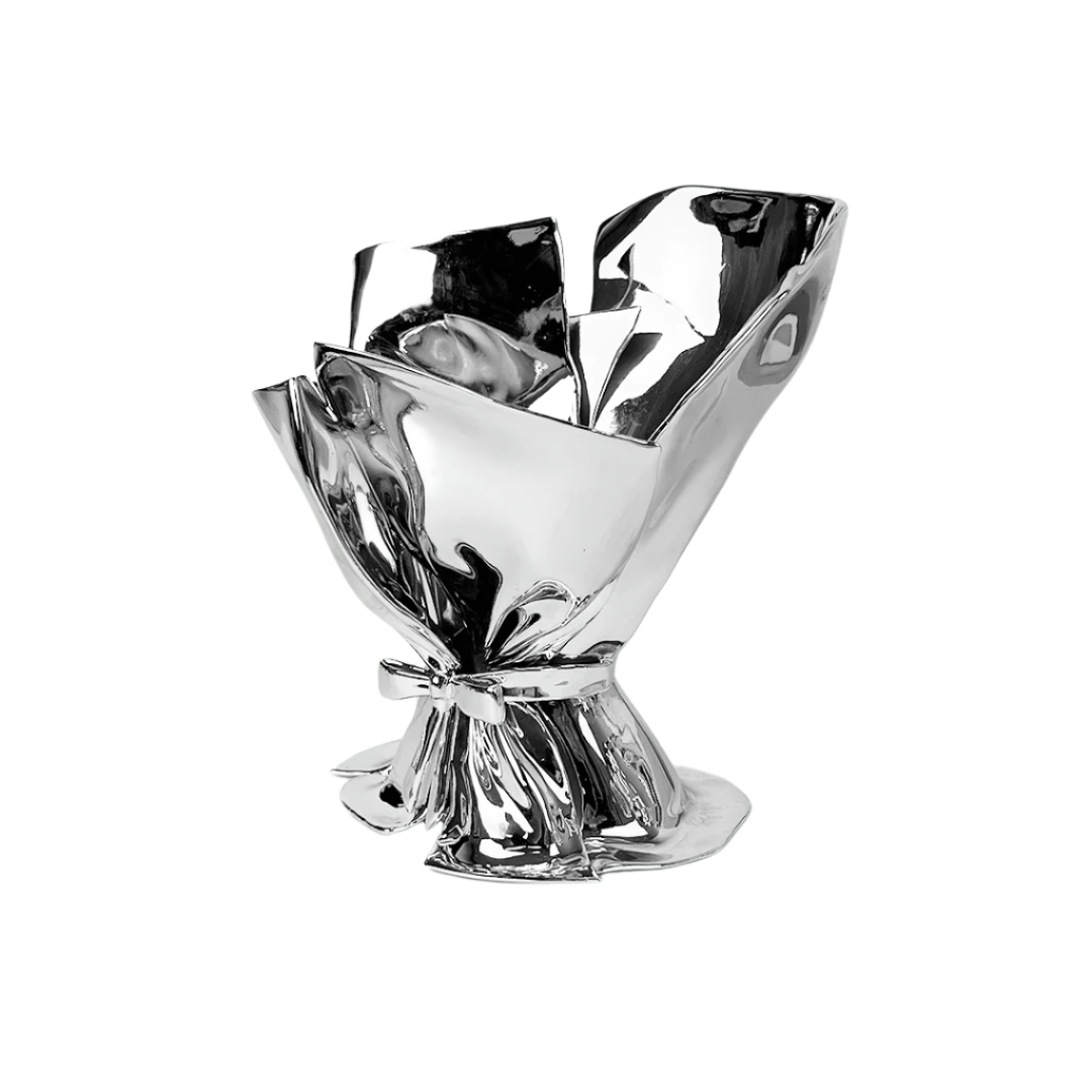 Futuristic chrome bouquet vase with sculptural ribbon tie – reflective metallic “petal” sheets gathered at the base, forming an abstract floral vessel
