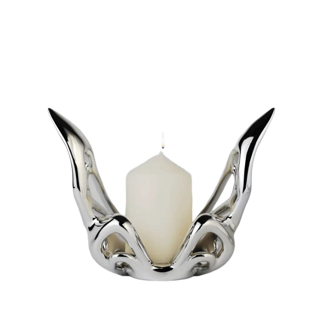 Futuristic chrome butterfly candle holder with wing-inspired curved frame – sculptural metallic design encasing a pillar candle