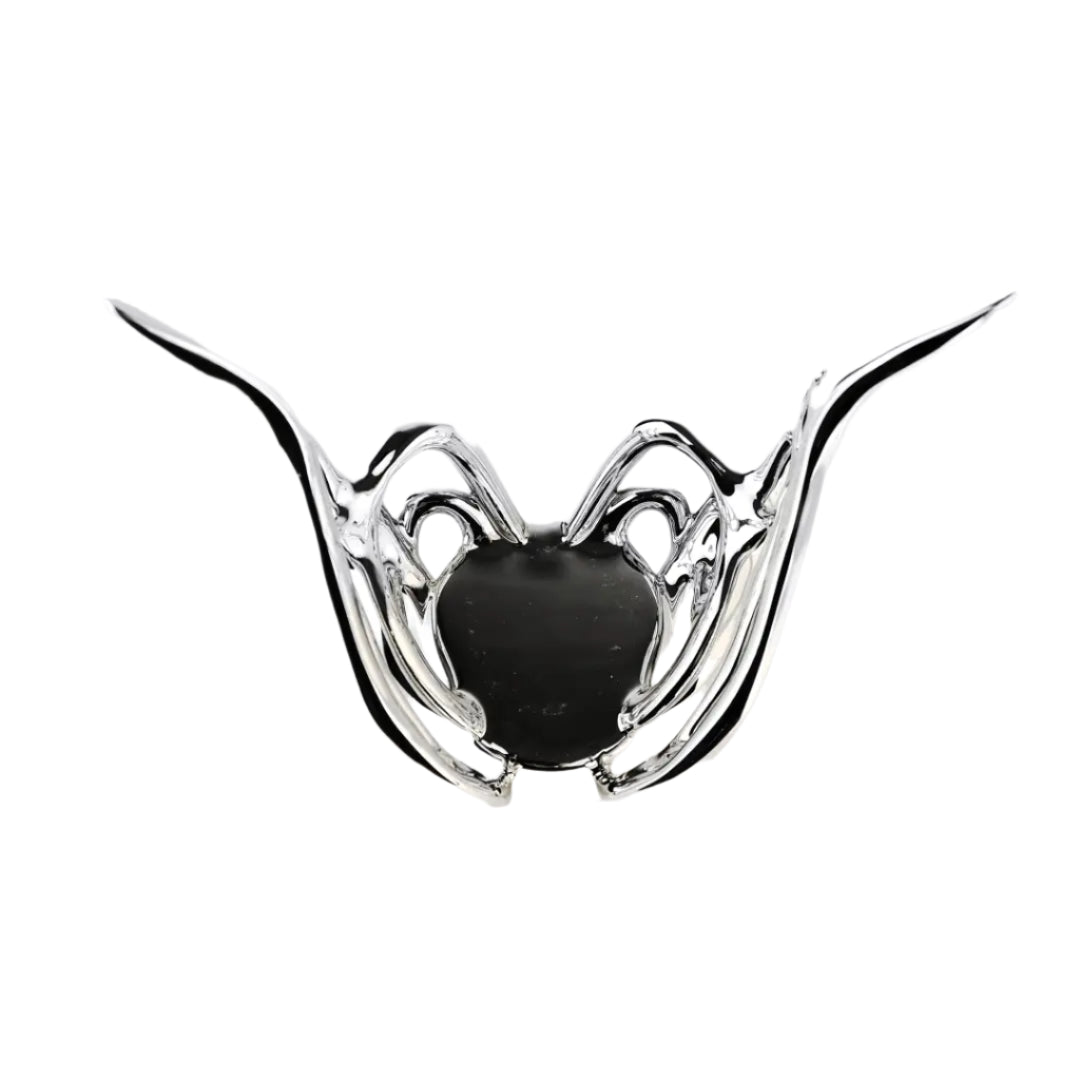 Futuristic chrome butterfly candle holder with wing-inspired curved frame – sculptural metallic design encasing a pillar candle