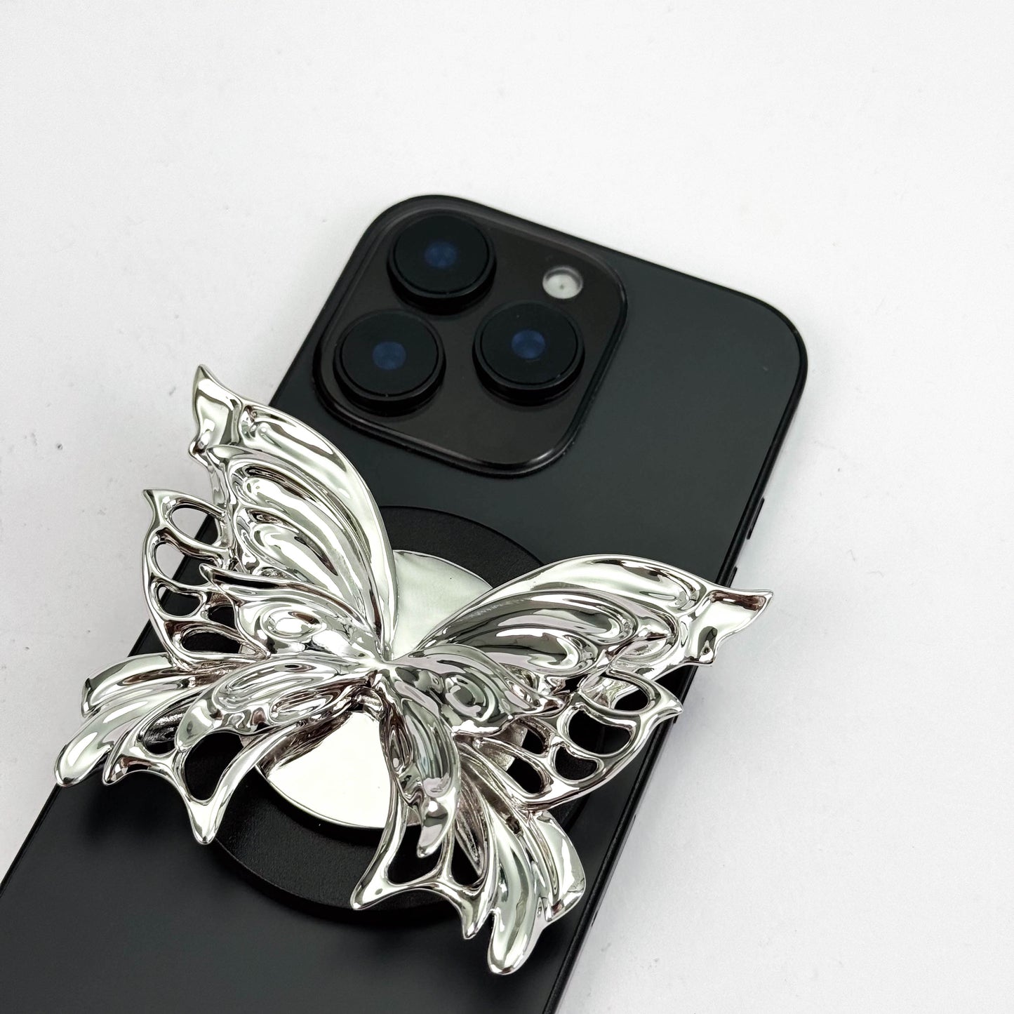 Butterfly-shaped phone stand on a black smartphone with a white background