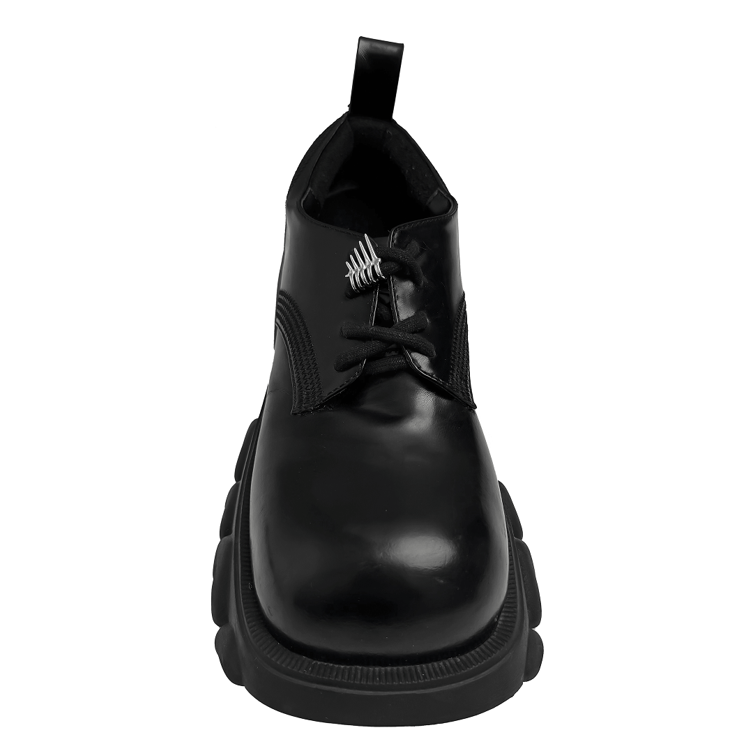 A metallic shoelace charm featuring claw-like spikes with looped rings, designed to slide onto shoelaces for a bold and edgy look.