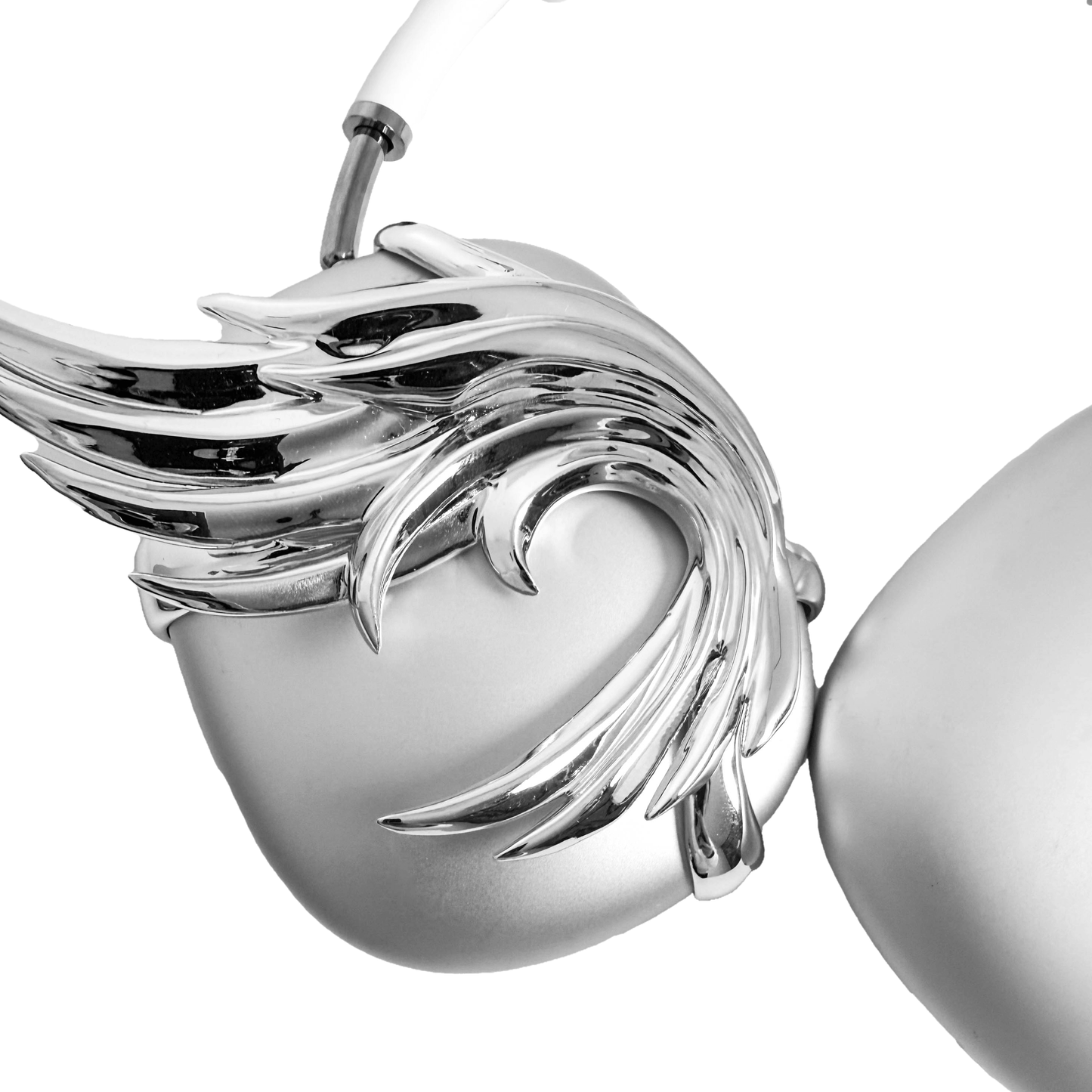 A sculptural 3D attachment for AirPods Max headphones featuring unique, upward-curled angel wings with layered feather details. Available in two finishes: Reflective Silver Chrome and Matte Ethereal White. Shown in both single ear cup and symmetrical pair configurations.