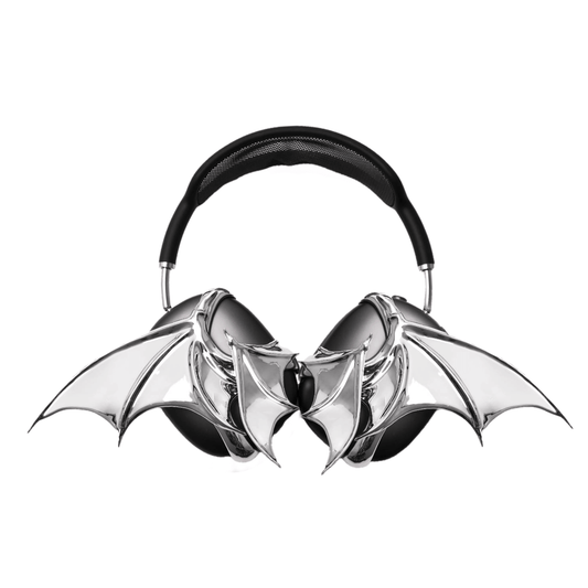 A high-fashion 3D attachment for AirPods Max headphones featuring sharp, sculpted demon wings. Available in two finishes: a high-shine Reflective Silver Chrome and a sleek Obsidian Black. The design is shown as both a single asymmetrical attachment and a symmetrical pair wrapping around the headphone ear cups.