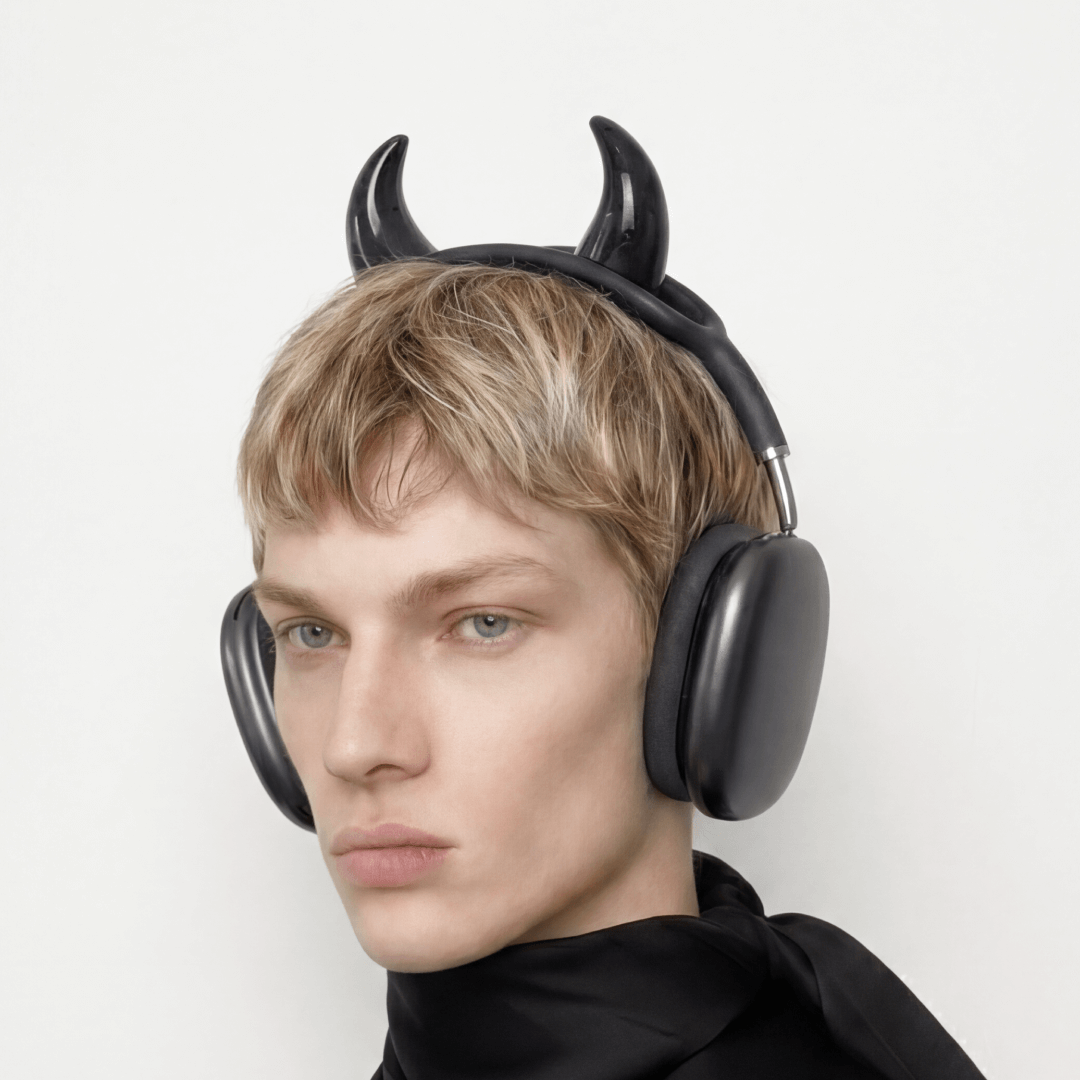 Person wearing black headphones with devil horns on a white background
