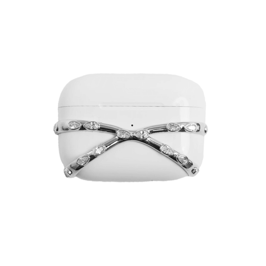 A minimalist, luxury AirPods cover featuring a crisscross metallic frame encrusted with small white crystals. The design is shown in a reflective Silver Chrome finish, wrapping around the white AirPods case, compatible with AirPods 4 and Pro models.