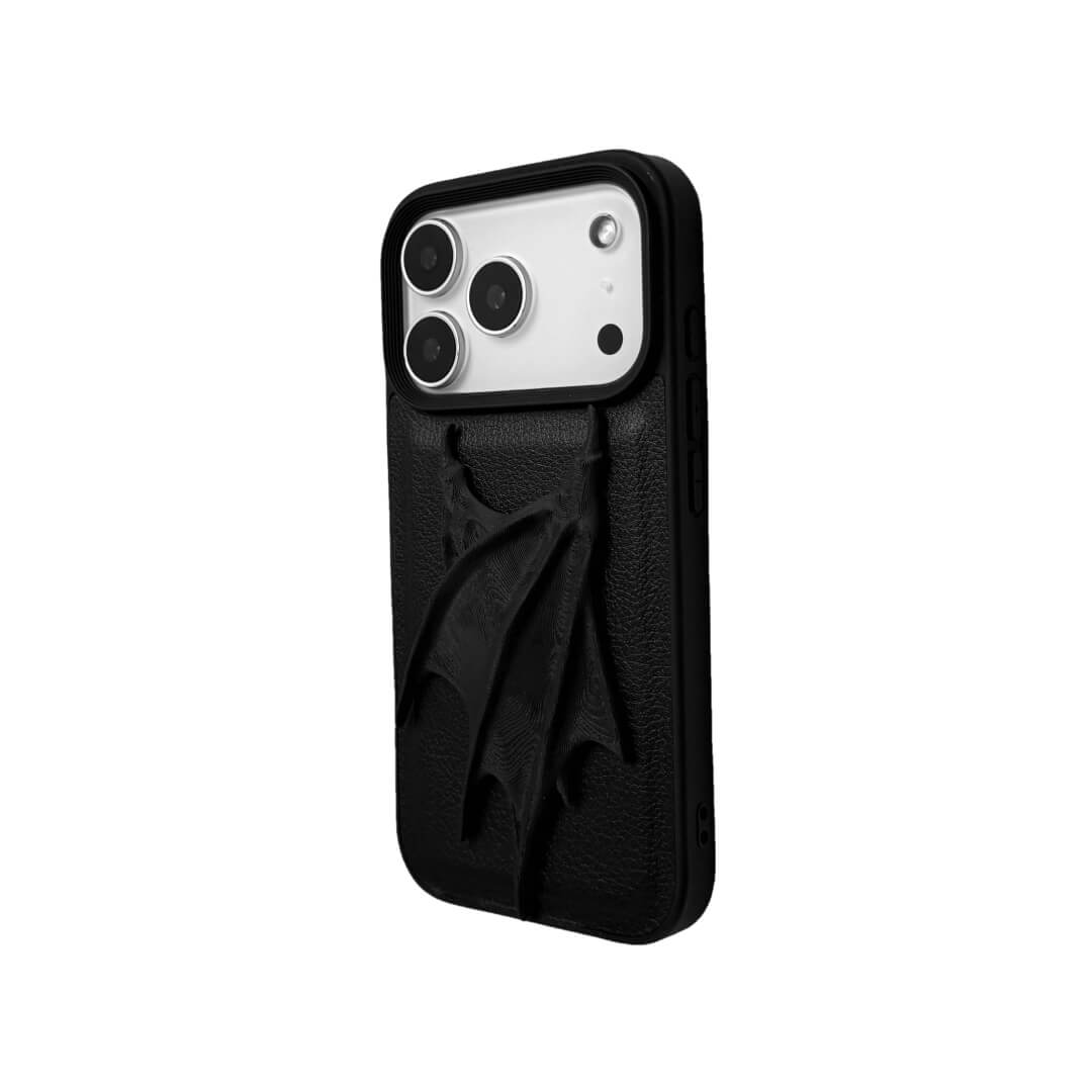 A high-concept iPhone case featuring a large, 3D-printed double demon wing ornament with a natural matte black finish. The wings are shown in two variations: one mounted on a Clear Transparent base, and another on a premium Black Litchi Leather textured base, highlighting the intricate, organic details of the sculptural wings.