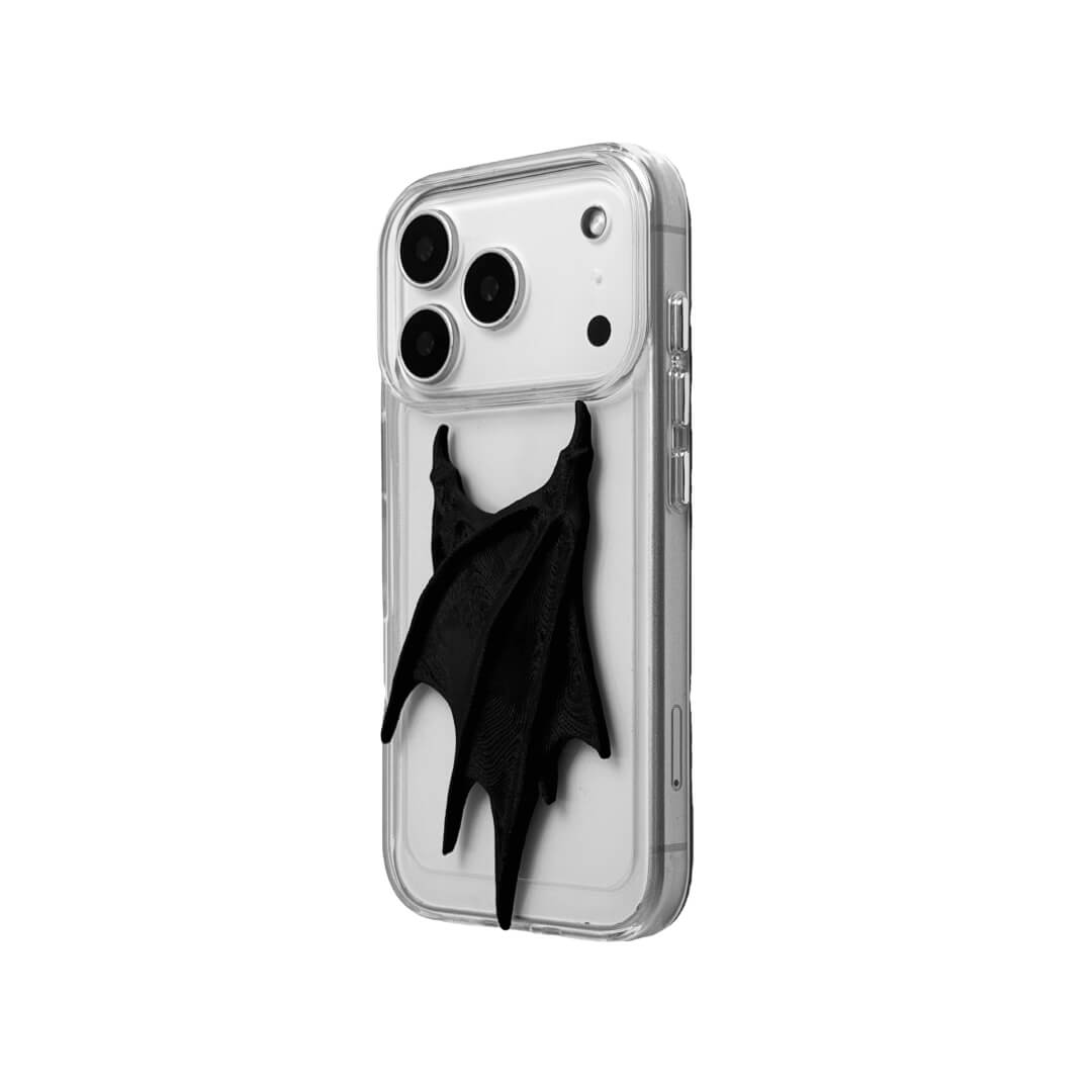 A high-concept iPhone case featuring a large, 3D-printed double demon wing ornament with a natural matte black finish. The wings are shown in two variations: one mounted on a Clear Transparent base, and another on a premium Black Litchi Leather textured base, highlighting the intricate, organic details of the sculptural wings.