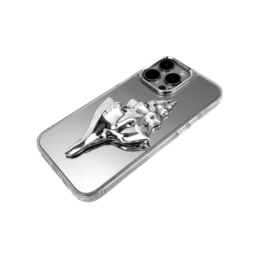 Metallic seashell-shaped phone case accessory with a sculpted, fluid spiral design and delicate pearl-like embellishments.