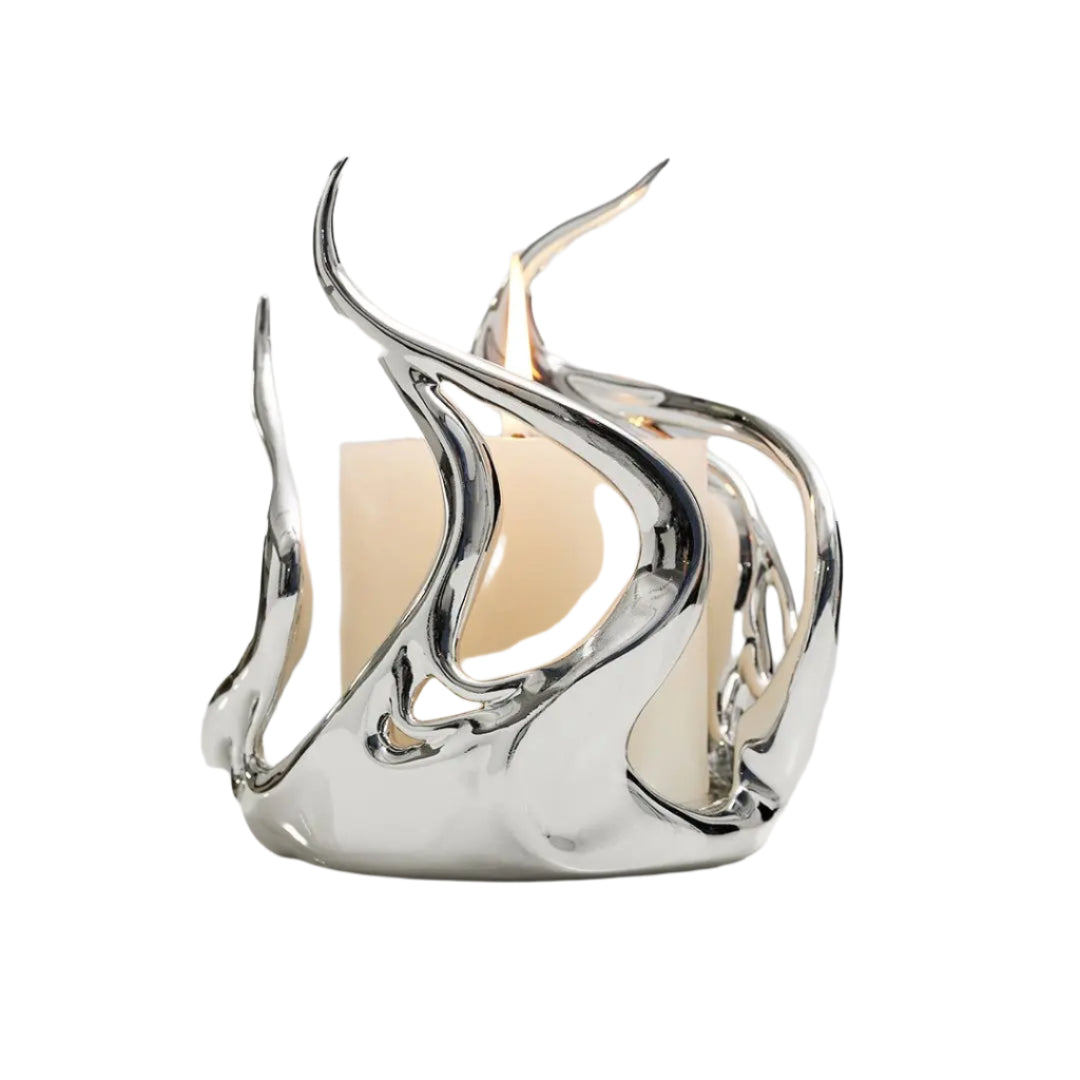 Sculptural silver candleholder with flowing flame-like curves embracing a short ivory candle — modern centerpiece for elegant decor