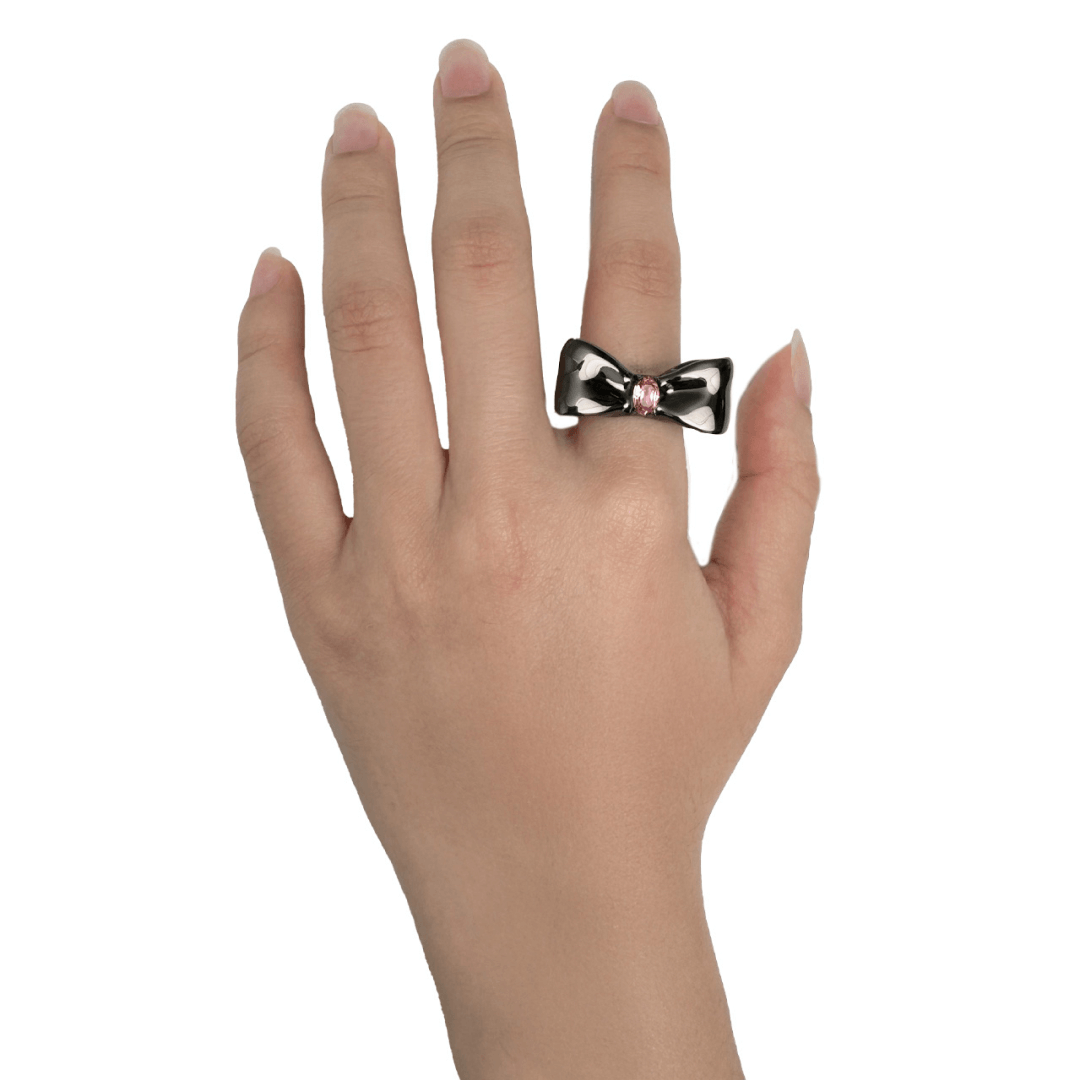 Elegant bow-shaped ring in silver and black with a pink Swarovski crystal at the center.