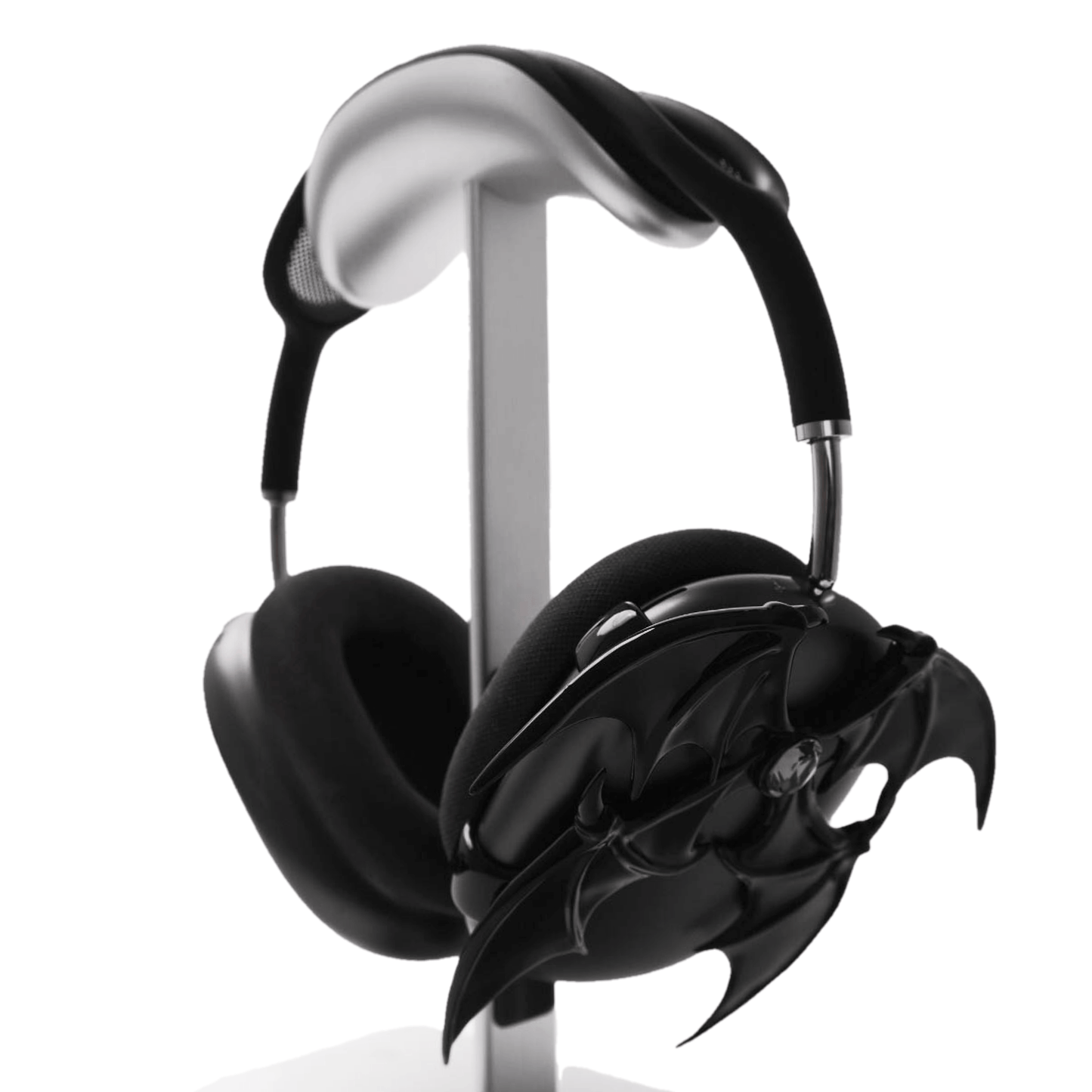 A high-fashion 3D attachment for AirPods Max featuring sharp, layered demon/bat wings with a central black Swarovski crystal on each ear cup. Available in two finishes: Reflective Silver Chrome and Sleek Nocturnal Black, shown in both single and pair configurations.
