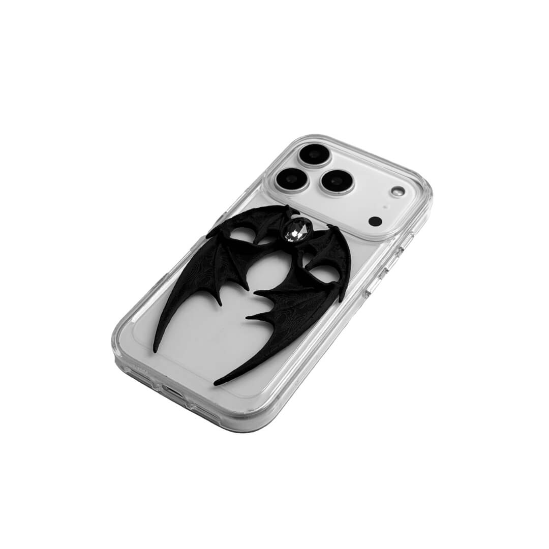 A high-fashion iPhone case featuring a pair of 3D-printed demon wings curving around a central sparkling gem, all in a natural matte black finish. Available in two variations: a minimalist Clear Transparent base and a luxurious Black Leather textured base, showcasing the intricate and edgy sculptural design.