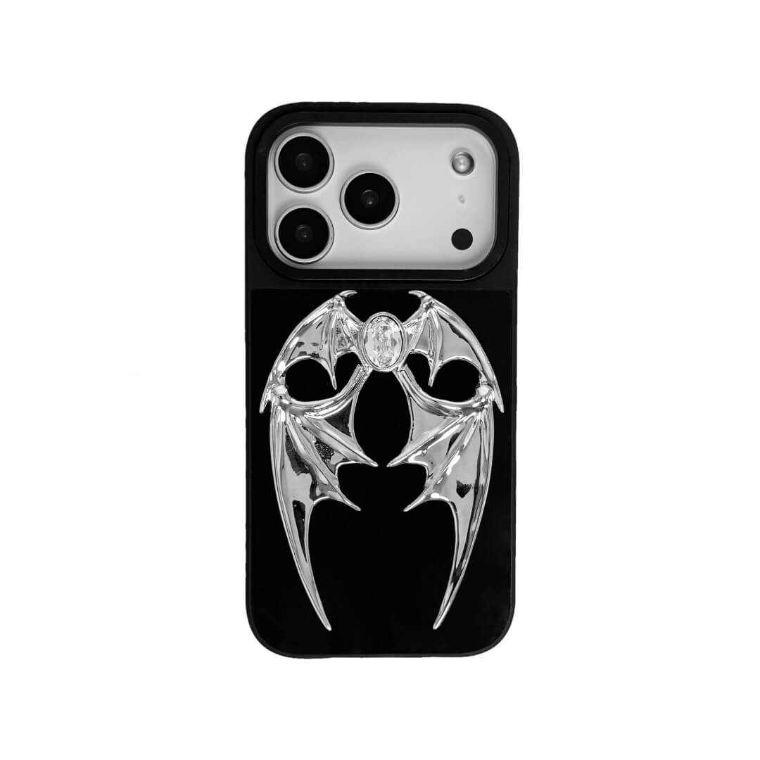 The Gem Demon Wings iPhone Case featuring 3D sculpted silver metallic bat-style wings with a central rhinestone. Shown with both White and Black gem options, available on Silver, Transparent, and Black case bases.