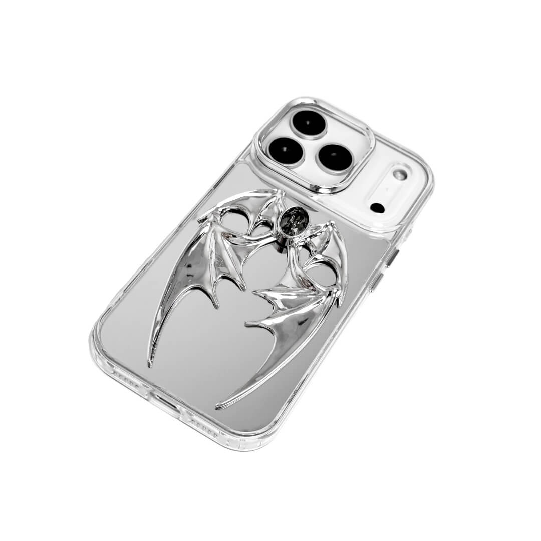 The Gem Demon Wings iPhone Case featuring 3D sculpted silver metallic bat-style wings with a central rhinestone. Shown with both White and Black gem options, available on Silver, Transparent, and Black case bases.